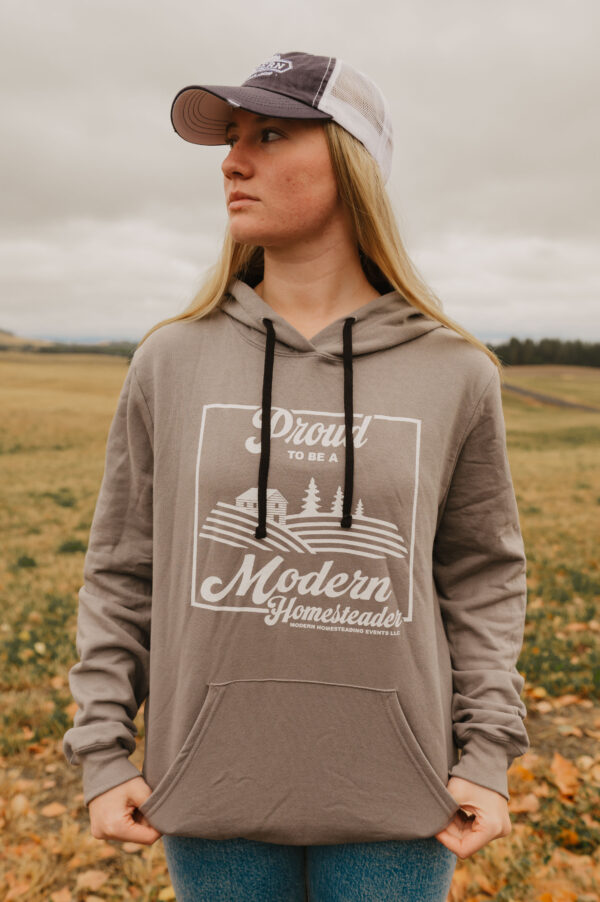 Woman in field wearing a grey Proud to Be a Modern Homesteader Sweatshirt