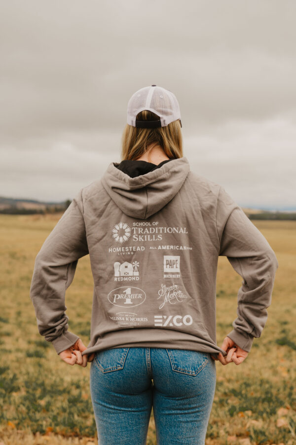 Woman wearing a grey sweatshirt in a field